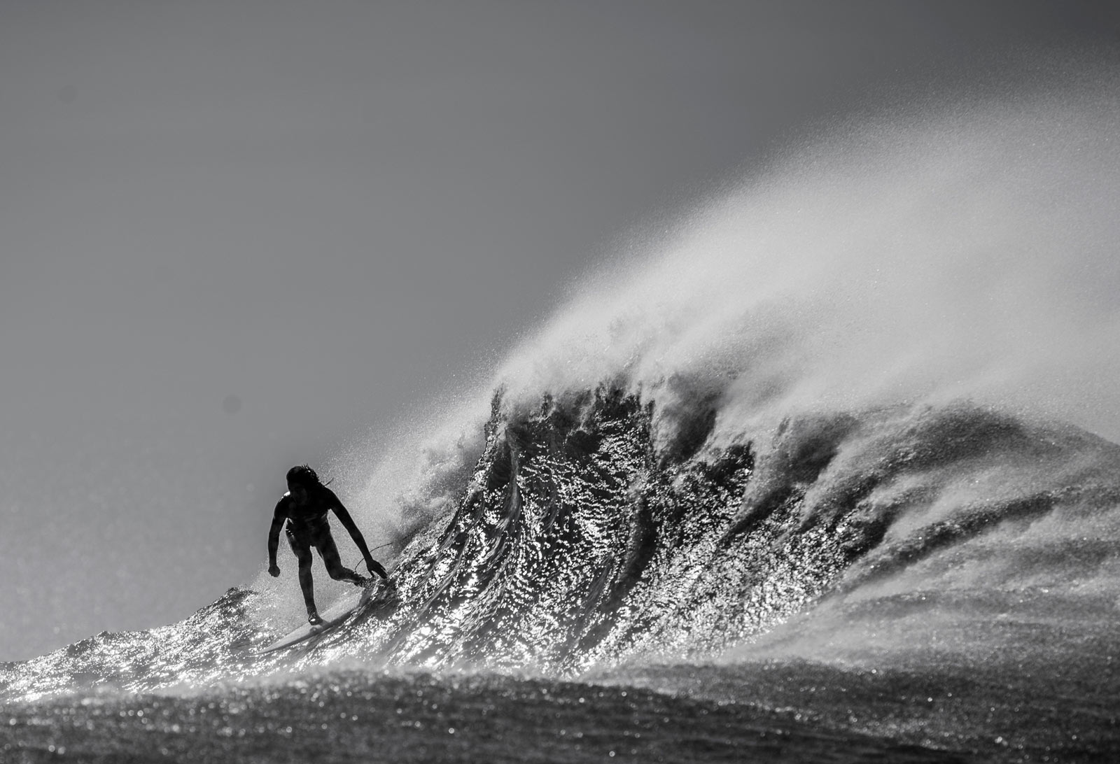 Black and White photo of Craig Anderson surifng a late afternoon wave